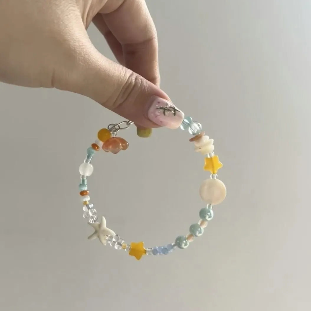 Orange seaside bracelet for women with diamond-shaped charm and round decorative elements on mixed material band