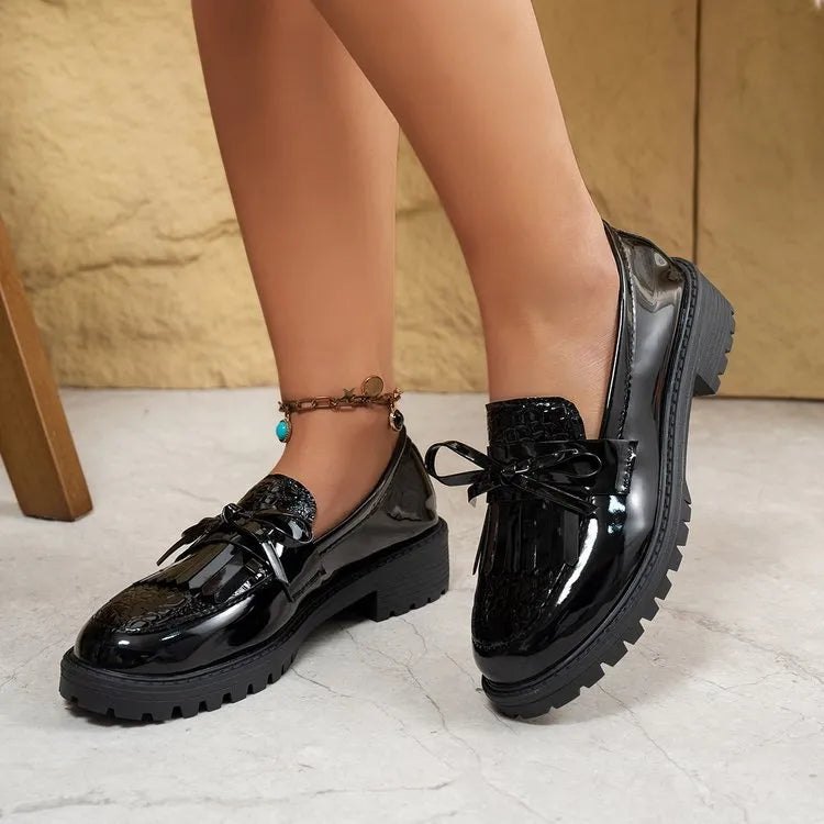Women's brown loafers with a decorative bow on the front.