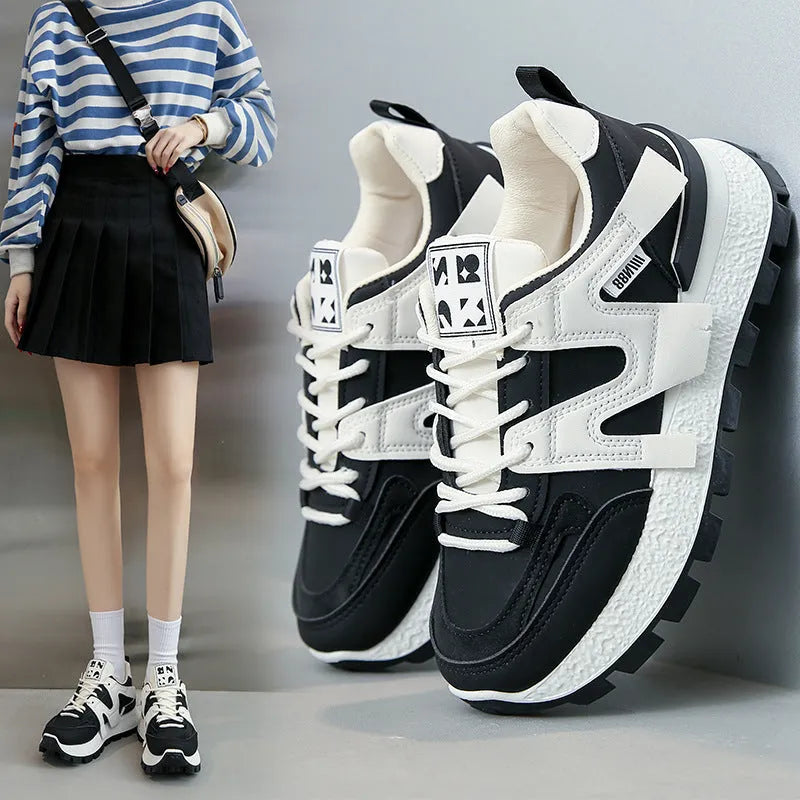 Low-top white and black casual sneakers with round toe and lace-up closure on a plain background.