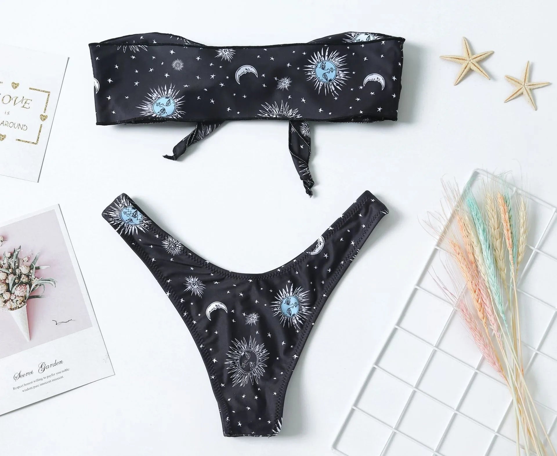 Black one-piece swimsuit with bikini print, featuring a split tube top and backless design.