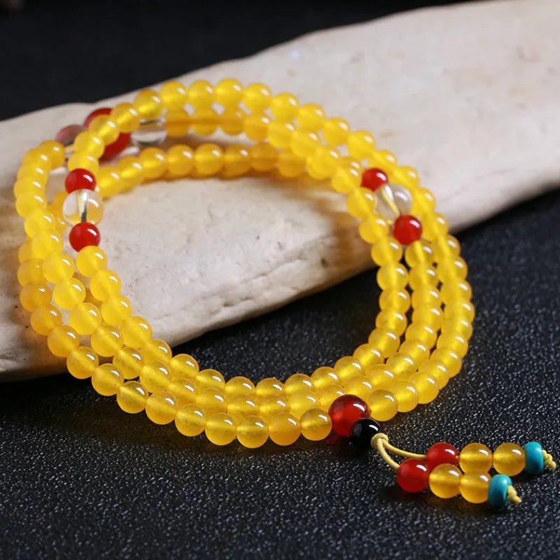 Polished crystal canary stone 108-bead geometric necklace with Lucky Cat detail on white background