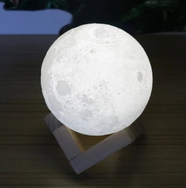 Luna Tranquil Moon Lamp with realistic moon texture and touch colour control on a bedside table