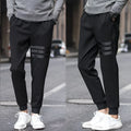 Men's casual slim sweatpants in black with elastic waistband and drawstring, side pockets, tapered leg, polyester fibre fabric