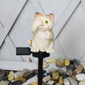 Brown cat-shaped solar-powered LED lawn light on grass