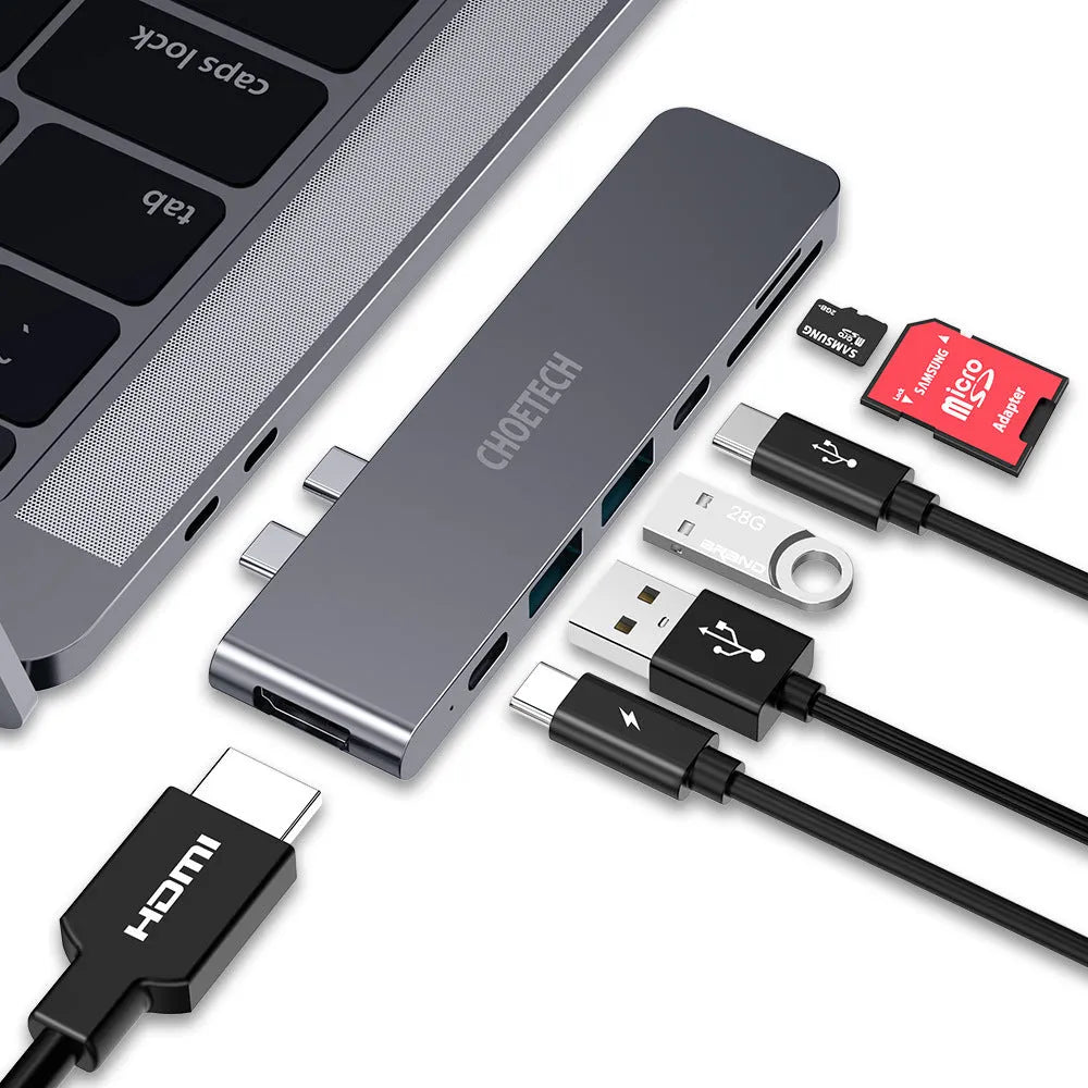 Compact silver USB-C multi-port adapter with SD card slot, HDMI, USB ports, and Thunderbolt 3 connector