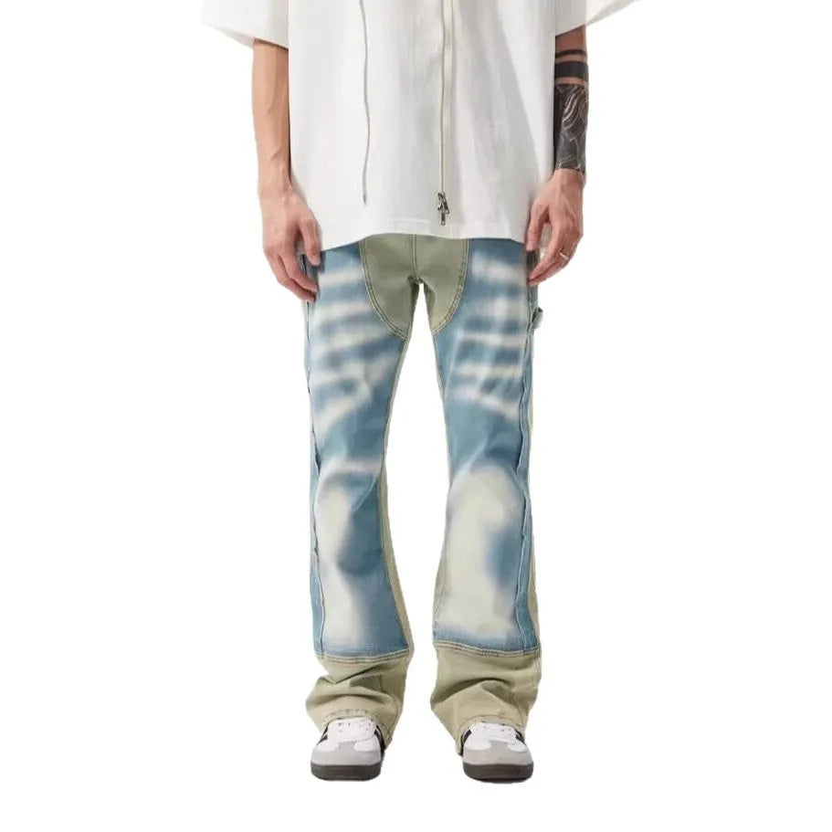 Yellow and blue retro patchwork jeans with a splash-ink damaged design, shown on a mannequin.