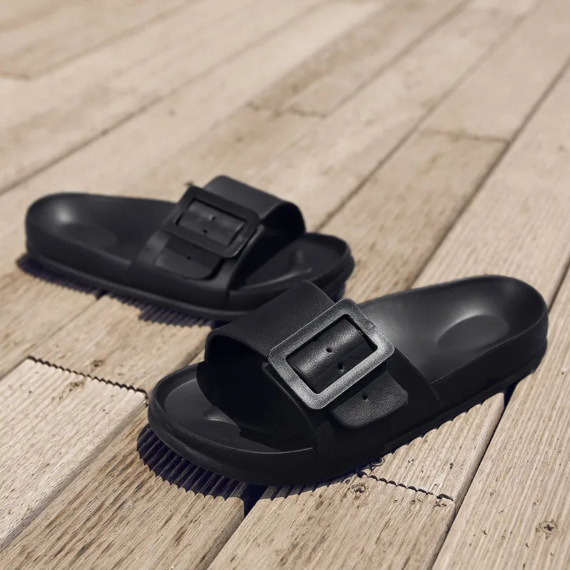 Women's grey blue buckle strap slippers with a soft EVA sole on a light background.