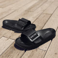 Women's grey blue buckle strap slippers with a soft EVA sole on a light background.