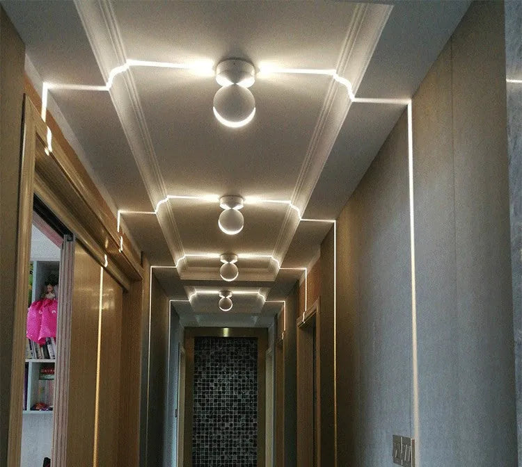 Modern aluminium LED spotlight bar wall lamp emitting coloured light, mounted on a wall.