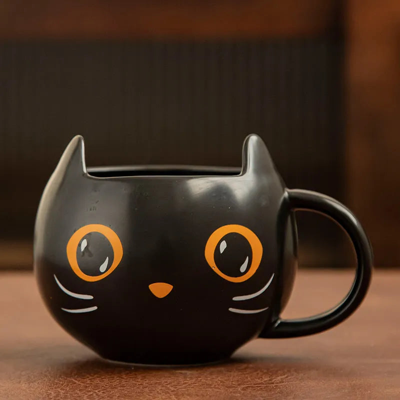 Black ceramic cat-shaped mug with pumpkin covered spoon on side