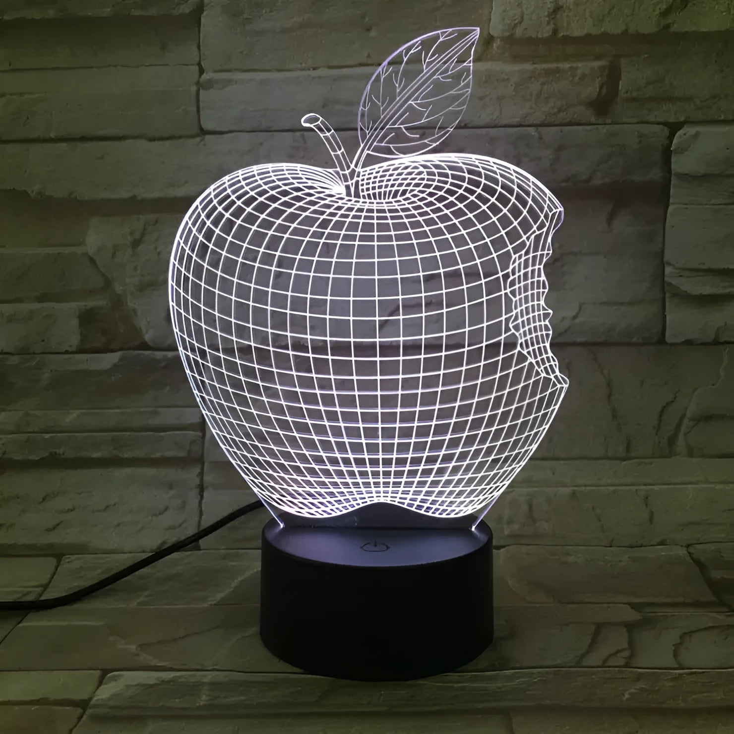 3D fruit-shaped colourful LED night light with touch control on a surface.