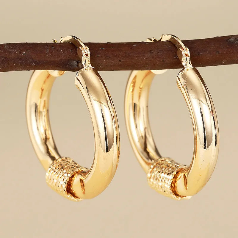 Geometric copper earrings for women with ring and line details in golden colour.