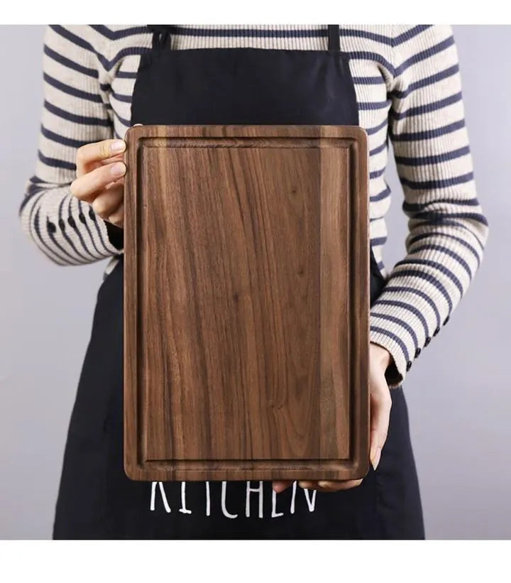 Black walnut wood cutting board with groove edge, rectangular shape, on kitchen counter