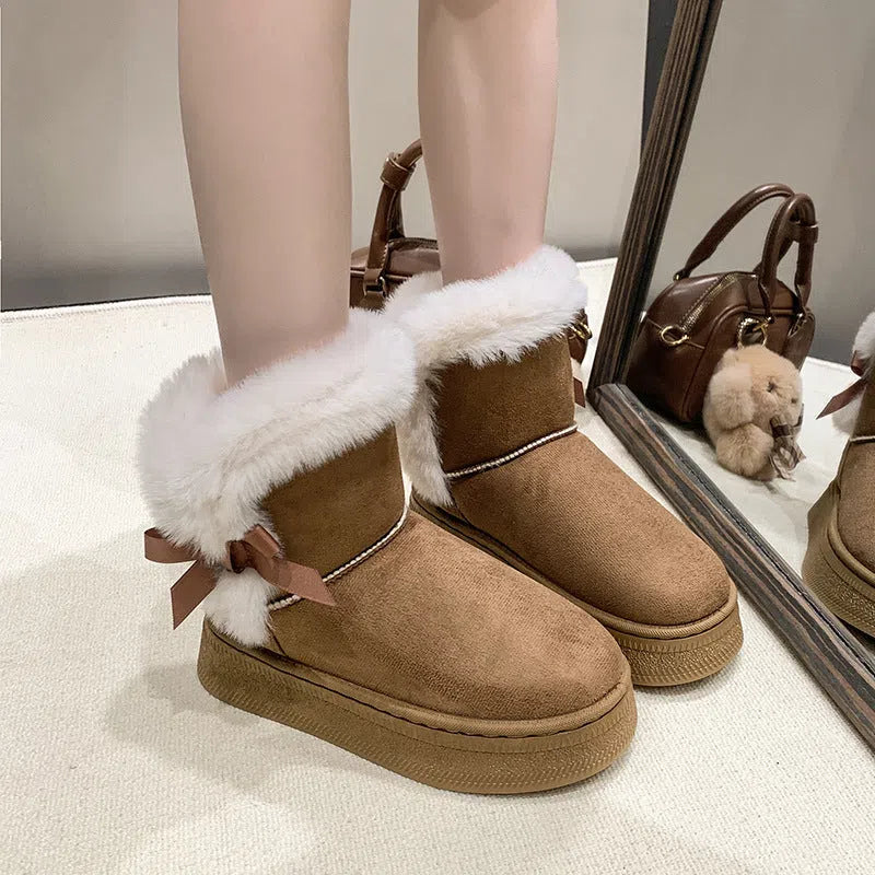 Women's mid-calf fleece-lined snow boots in brown with black rubber sole and bow tie detail