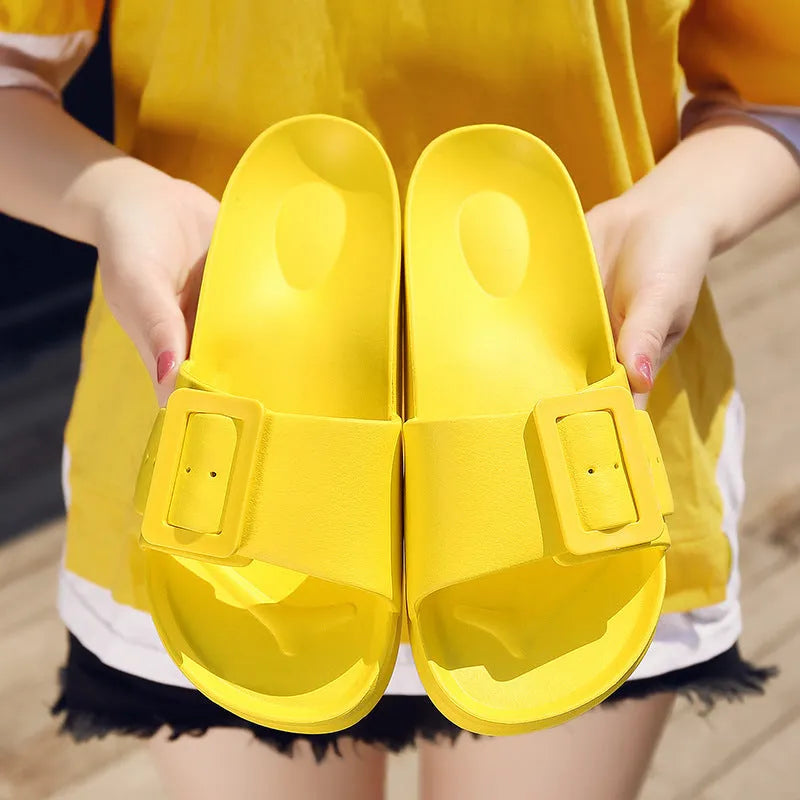 Women's grey blue buckle strap slippers with a soft EVA sole on a light background.