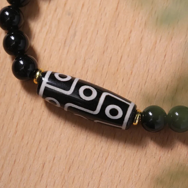 Ethnic style Tibet dzi bead bracelet in obsidian agate, unisex couple design on a neutral background