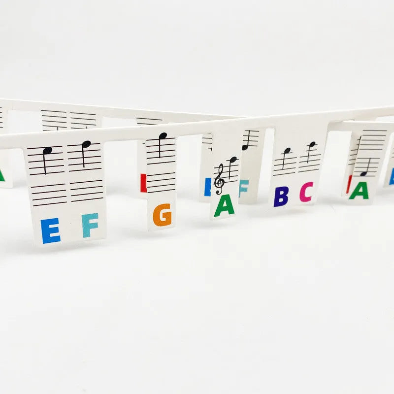 Piano keyboard stickers showing black music notes and colour note bars for 88-key instrument learning