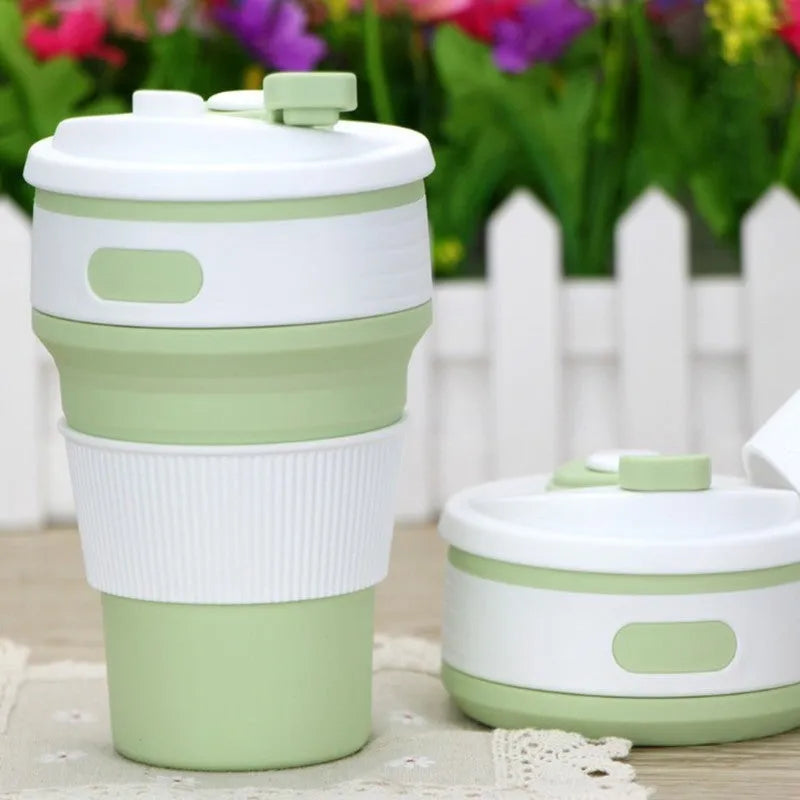 Collapsible silicone travel cup in pink folded to 6cm height with anti-hot handle and leak-proof lid