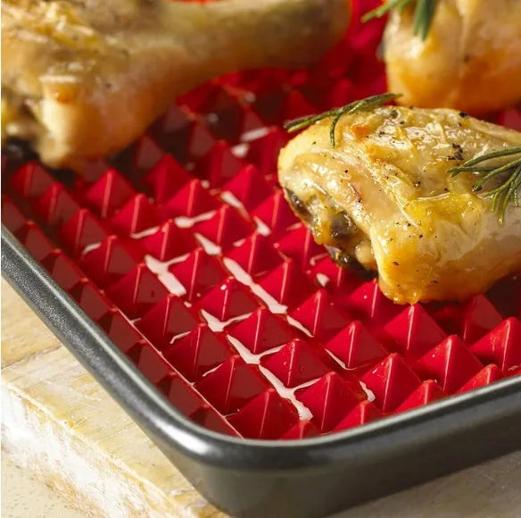 Red non-stick silicone pyramid cooking mat on a baking tray, showing grid pattern and 39.5 cm size