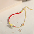 Gold 925 silver koi peace buckle bracelet with red rope on white background