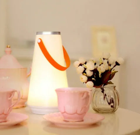 White LED rechargeable night light on a bedside table, 12x12x22cm ABS plastic body with warm glow
