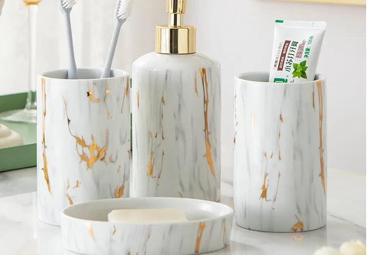 White marble ceramic bathroom wash kit with two cups, latex bottle, and soap box on a counter
