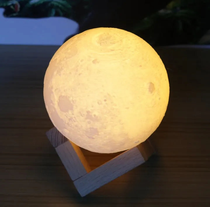 Luna Tranquil Moon Lamp with realistic moon texture and touch colour control on a bedside table