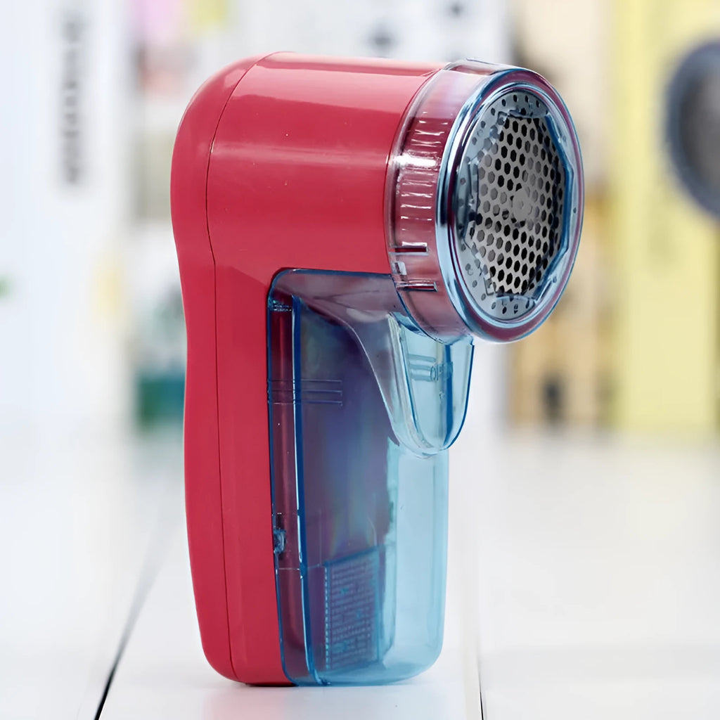 Handheld portable electric lint and pill remover for sweaters on a blue background.