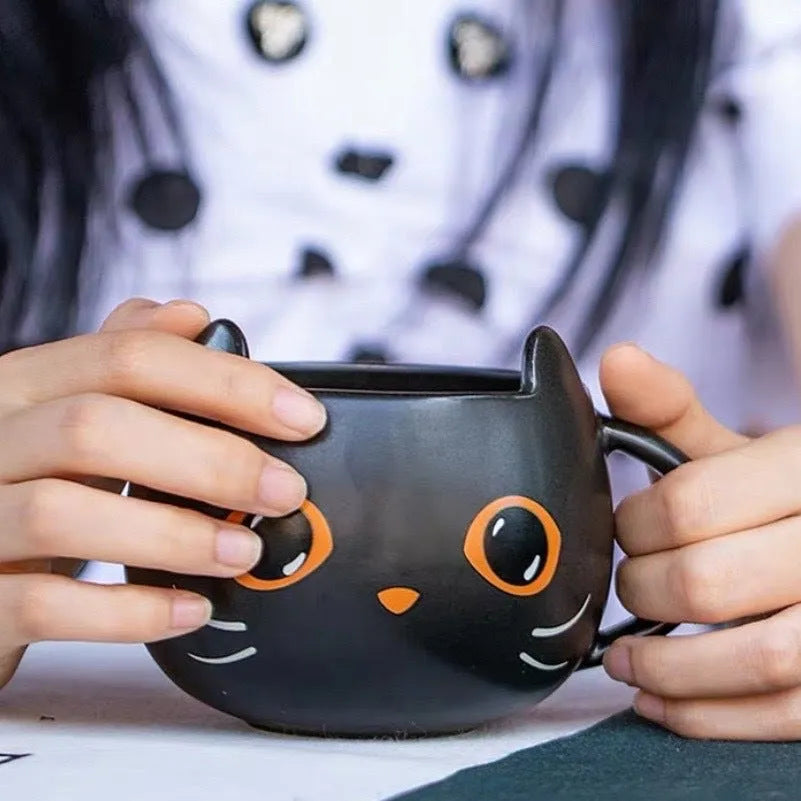 Black ceramic cat-shaped mug with pumpkin covered spoon on side