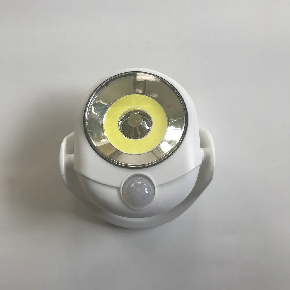 White Atomic Angel induction lamp on surface showing compact 13.3 cm height and ABS plastic construction.