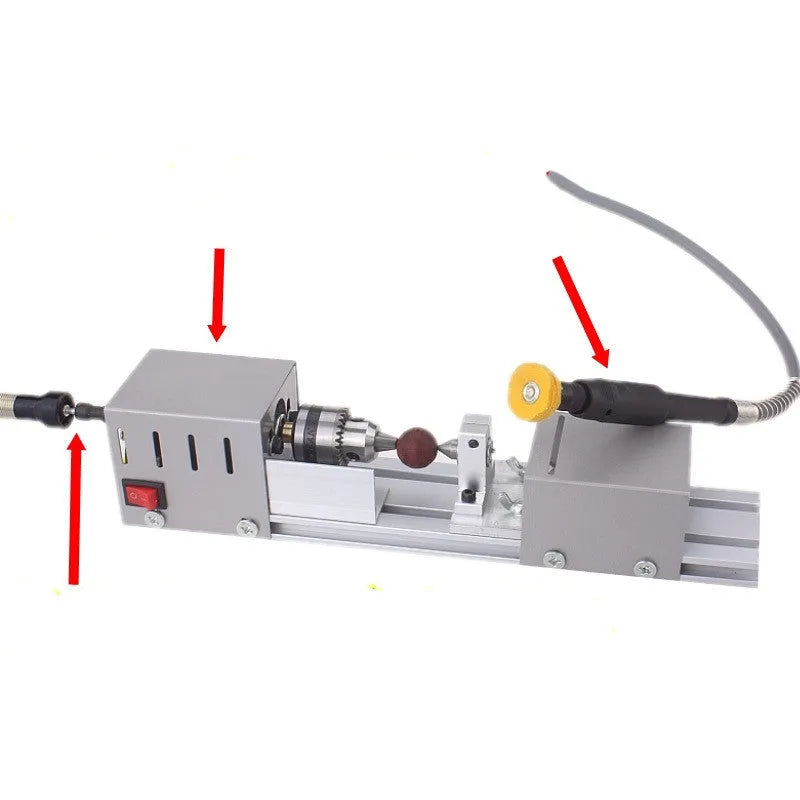 Compact metal mini woodworking lathe on a bench with carving tools, showing small turned wooden spindle.