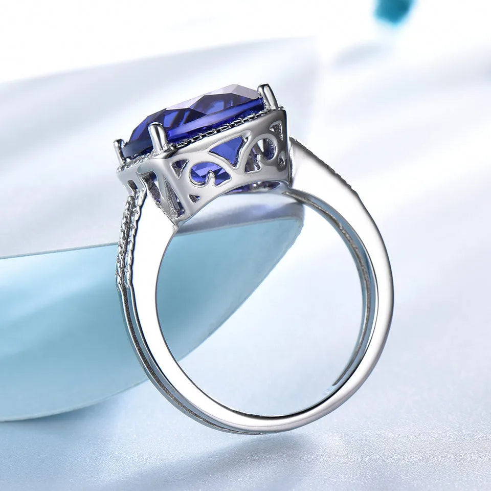 Blue Tanzanite gemstone set in a sterling silver women's ring on a white background.