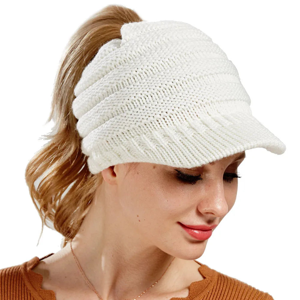 A soft grey acrylic knitted beanie for women, worn over a ponytail.