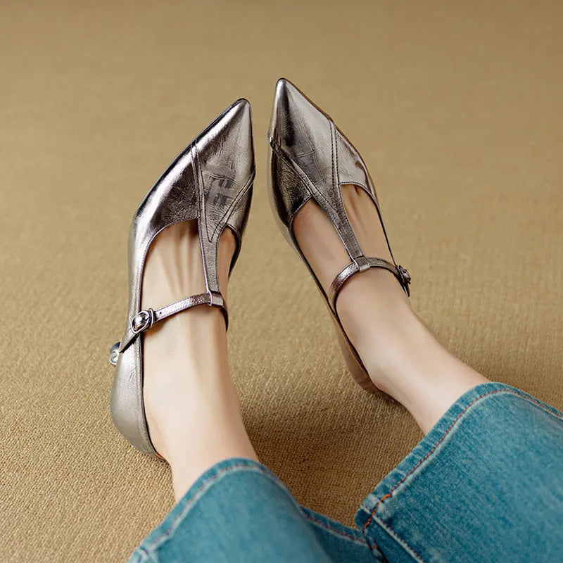 Women's gun metal grey pointed-toe pumps with a chunky mid heel on a rubber sole.