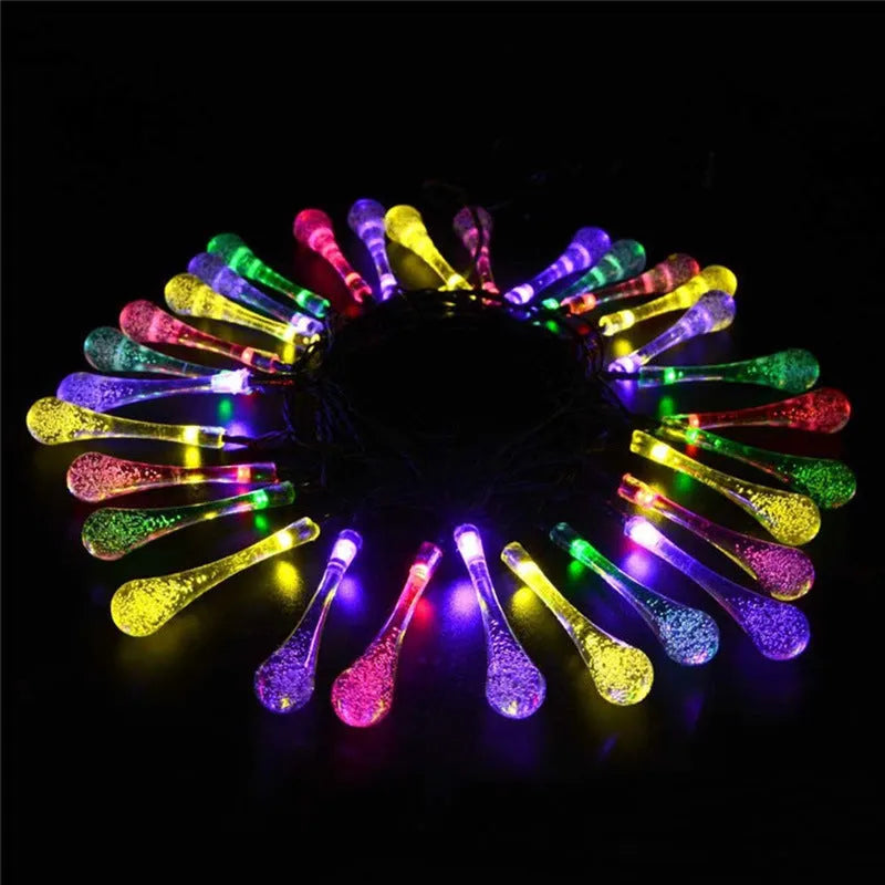 6.5 metre long solar-powered LED garden string lights with white bubble drop shaped lamps on a green lawn