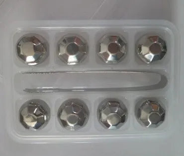 Set of 8 stainless steel ice cubes in square and ball shapes with plastic storage box and tong on a wooden surface