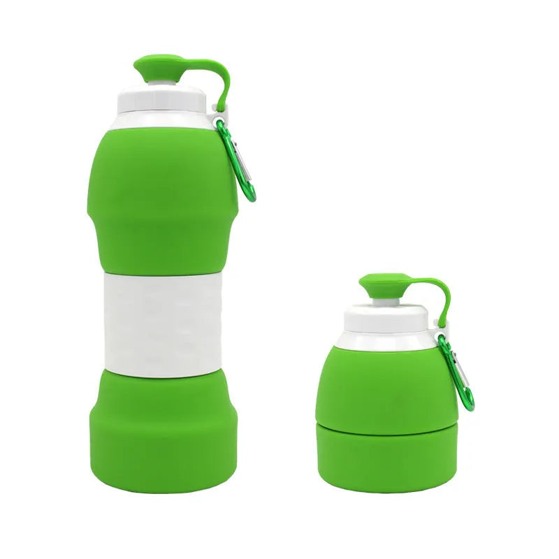 Silicone folding water bottle 580ml in blue, collapsed and full size, with cap, on outdoor background