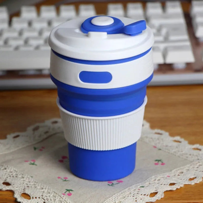 Collapsible silicone travel cup in pink folded to 6cm height with anti-hot handle and leak-proof lid