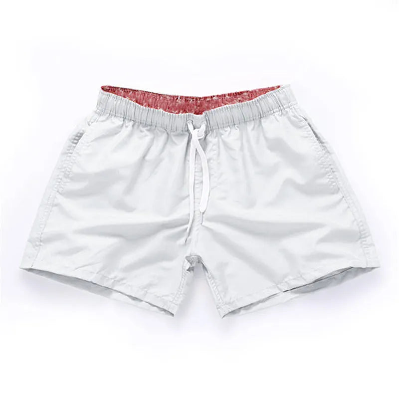 Men's straight-leg beach shorts in black polyester fabric on a size chart.