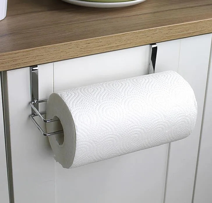 Silver stainless steel paper towel rack hanging on the back of a kitchen cabinet door.