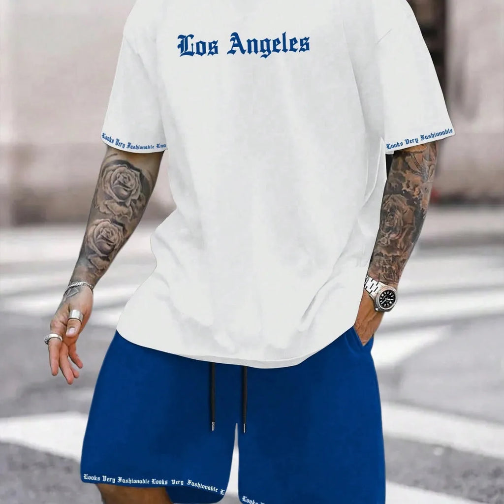 Man wearing a blue printed short-sleeved top and matching shorts from a sports-style two-piece set.