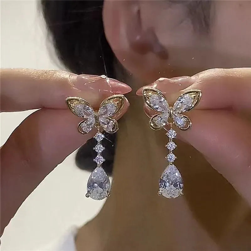 Pair of zinc alloy bow stud earrings with electroplated platinum finish on a white background
