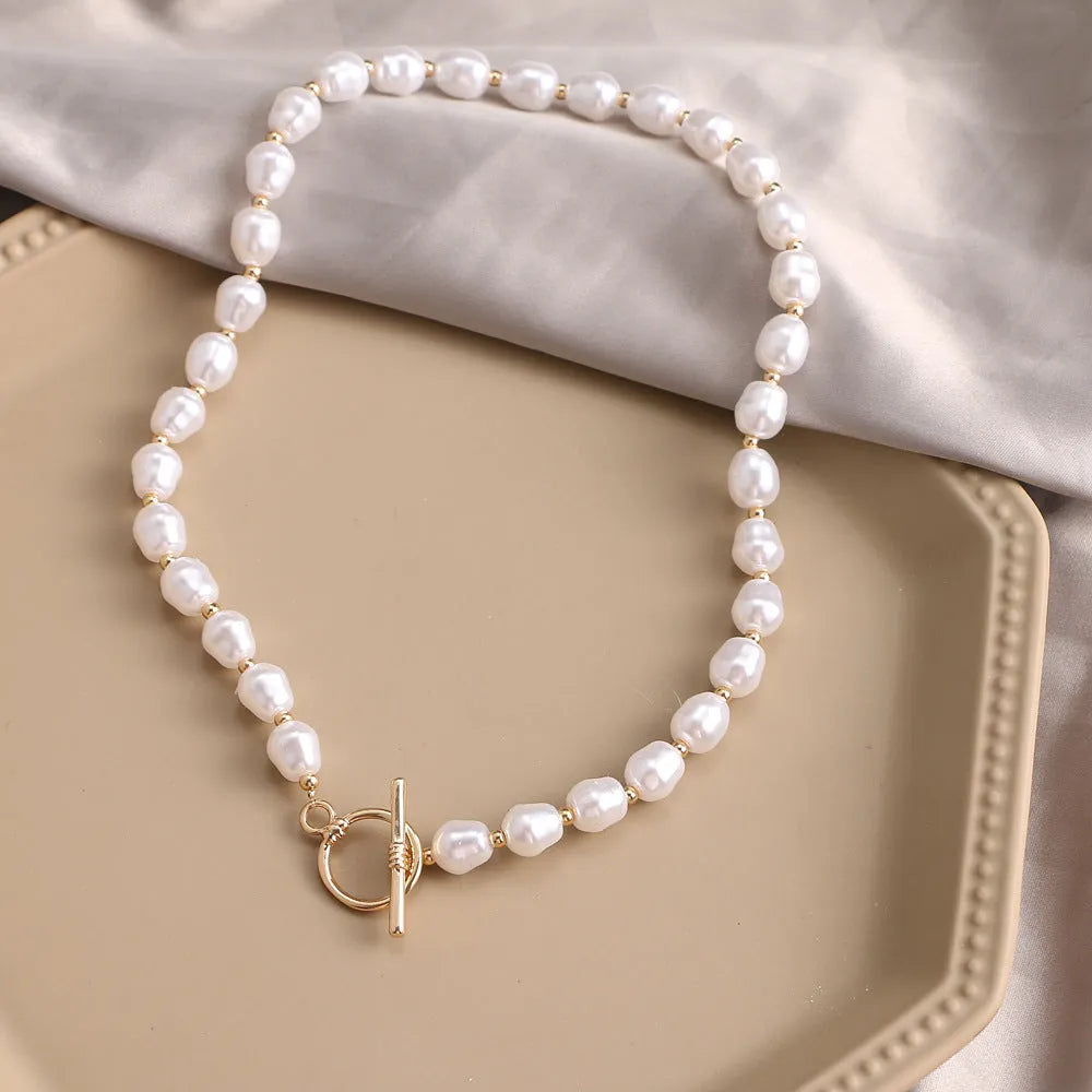 Vintage gold necklace with heart pendant on pearl chain showing adjustable length mechanism