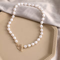 Vintage gold necklace with heart pendant on pearl chain showing adjustable length mechanism