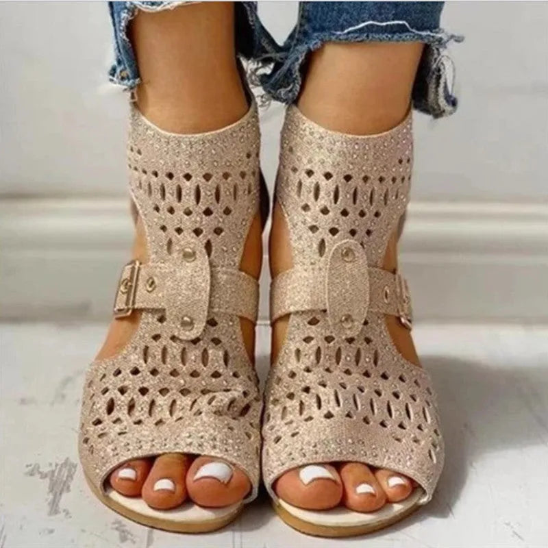 Women's beige flat sandals with a fish mouth toe, low wedge heel, and a back zipper fastener.