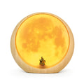Creative hidden moon light LED touch lamp with ABS shade in blue on a wooden bedside table