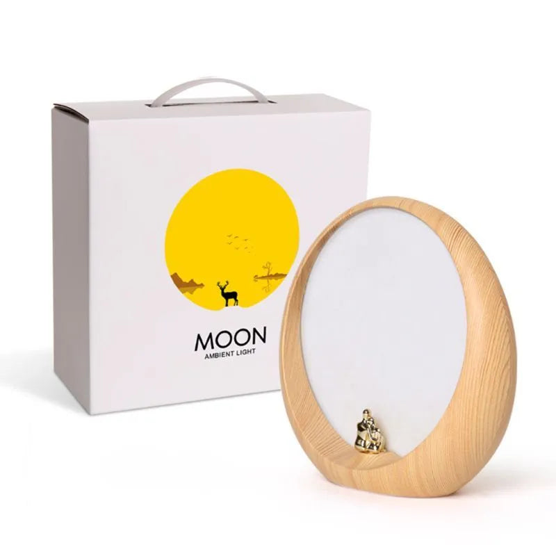 Creative hidden moon light LED touch lamp with ABS shade in blue on a wooden bedside table
