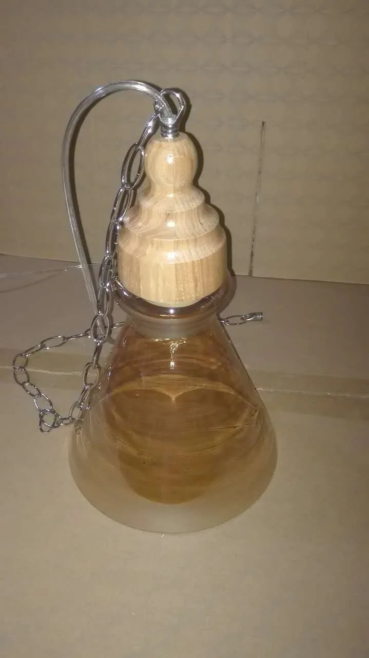 Glass wood grain single head pendant light hanging on an adjustable cord.
