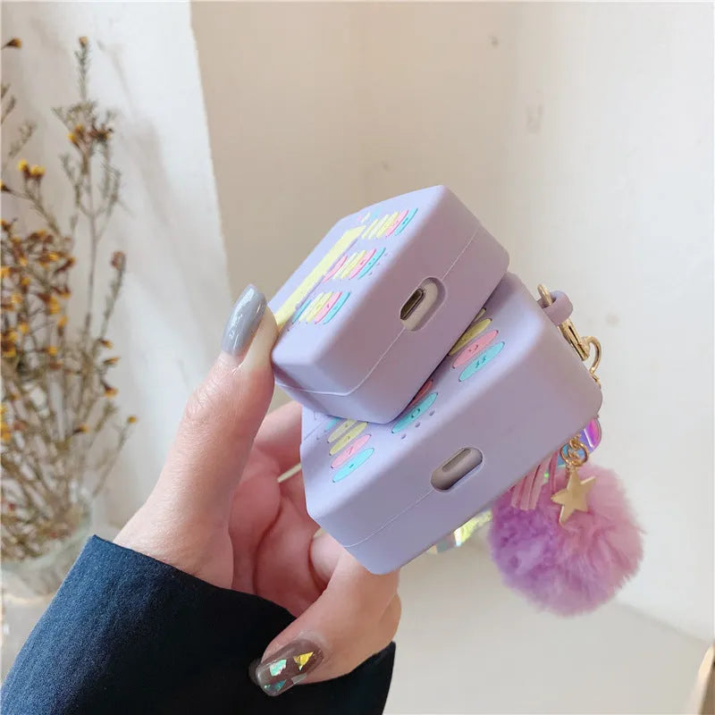 Purple silicone case for Apple wireless headphones with clamshell design and fur ball pendant