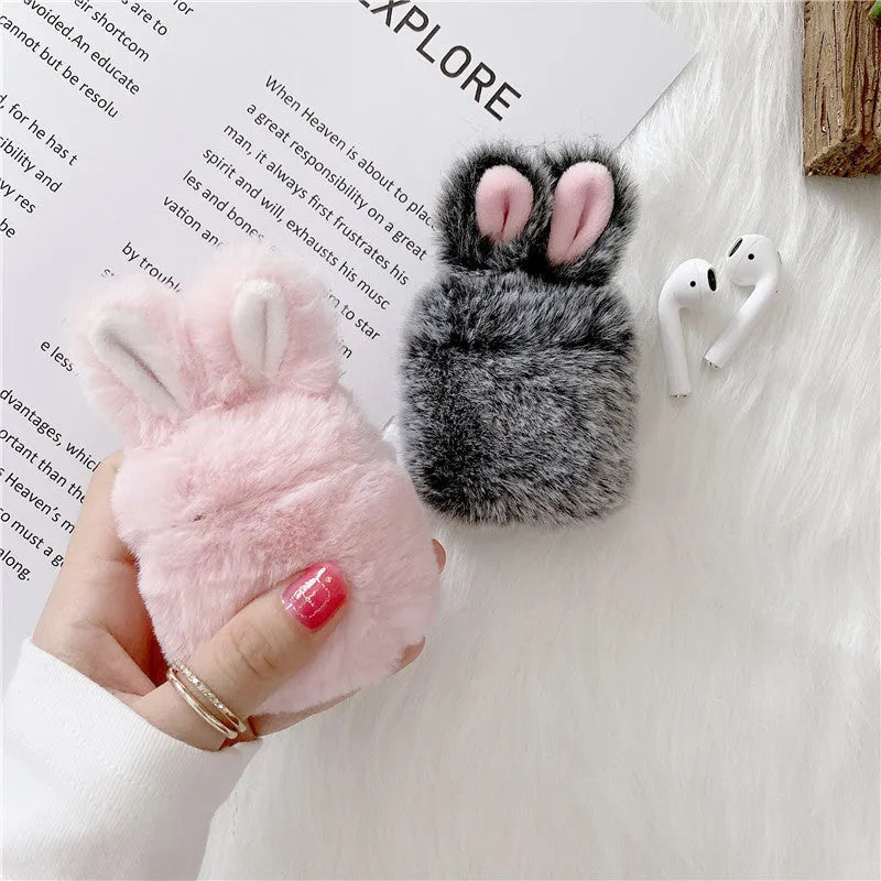 Pink soft silicone Airpod protective cover with grey plush rabbit ears attached to the top.
